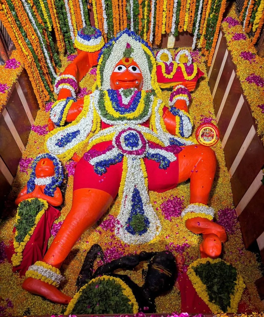 Reclining Hanuman Ji adorned with garlands